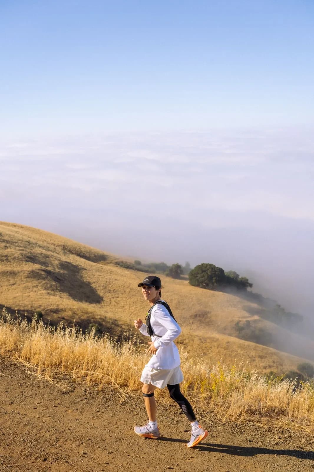 Runner passing golden hills and fog on Mount Diablo