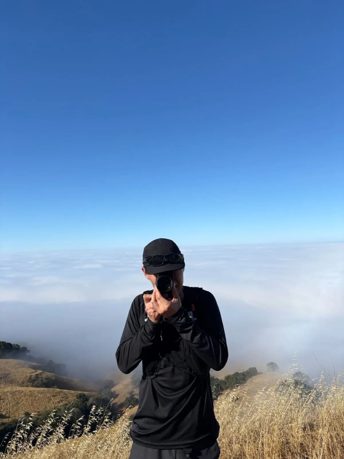 Runner photographing the view above the clouds